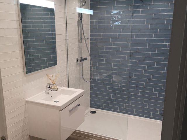 Completed bathroom refit with walk in shower and blue metro tiling
